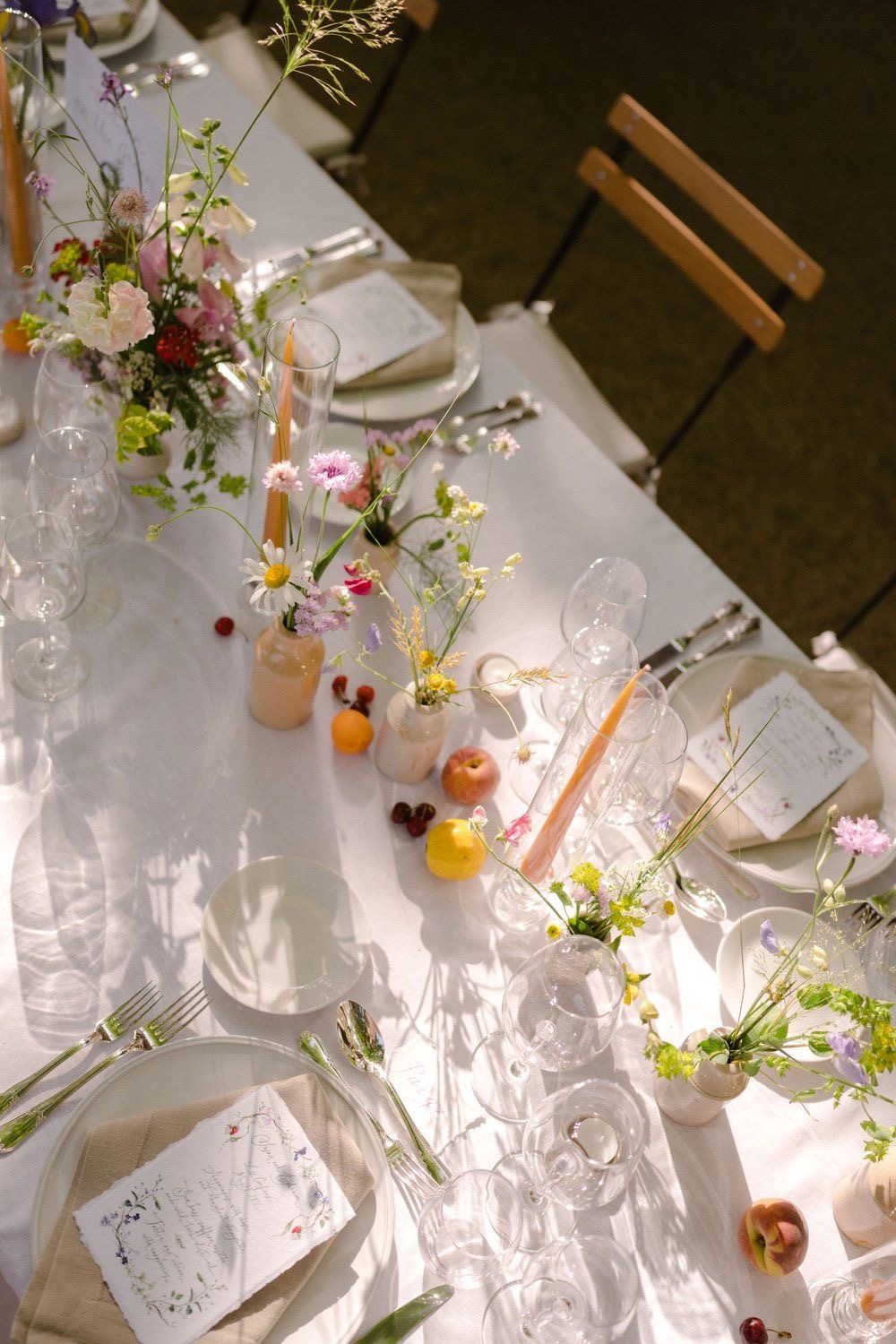 Tavola apparecchiata con luce naturale, fiori di campo e ceramiche